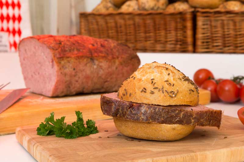 Eine Scheibe Leberkäse auf einem Kümmel-Brötchen