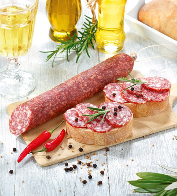 Grobe Chilisalami auf Baguette-Brot servierfertig auf einem Holzbrett