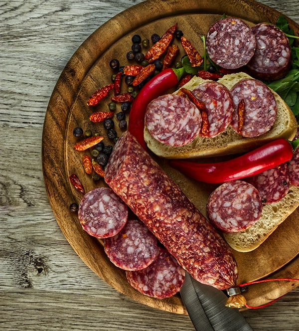 Grobe Chilisalami in Stückchen auf einem Brotzeitbrett