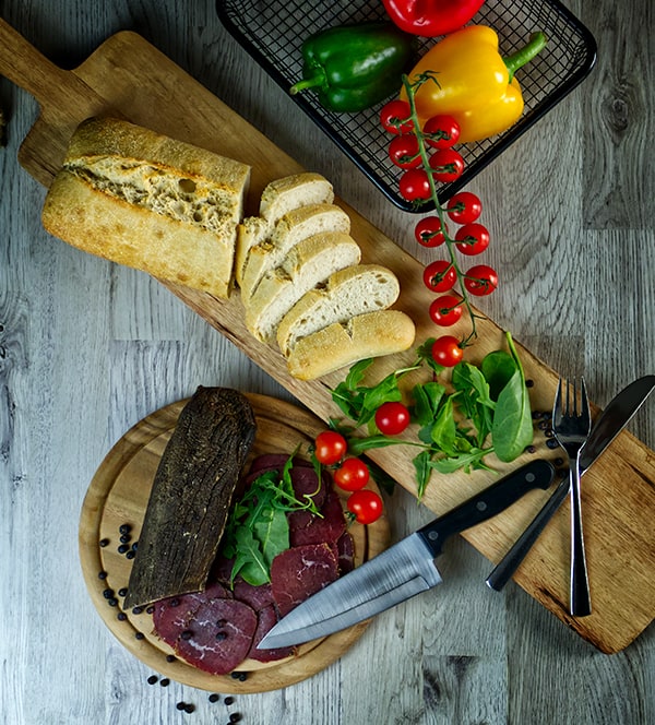 Zwetschgenbamas mit Brot, Tomaten geschmackvoll angerichtet